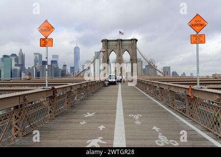 Blick auf die Brooklyn Bridge Fußgänger- und Radweg mit Schildern und Skyline im Hintergrund, Manhattan, New York City, New York, USA, Nordamerika Stockfoto