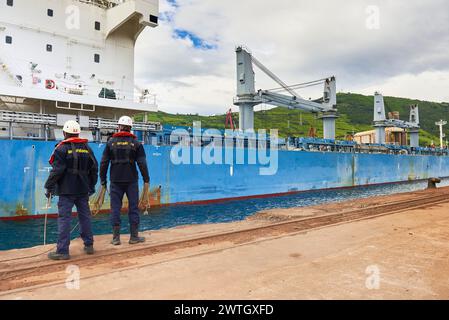 Zwei Hafenarbeiter, die ein Frachtschiff im Hafen von Bilbao, Biskaya, Baskenland, Euskadi, Spanien, Europa Stockfoto