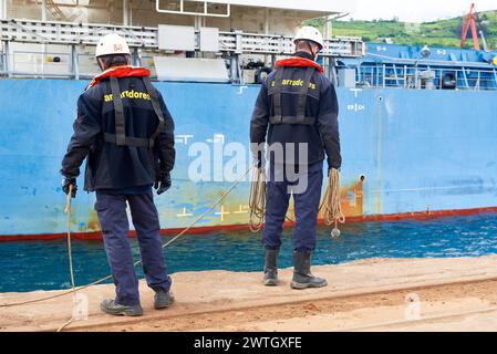 Zwei Hafenarbeiter, die ein Frachtschiff im Hafen von Bilbao, Biskaya, Baskenland, Euskadi, Spanien, Europa Stockfoto