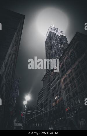 Abendlicher Blick auf das Empire State Building von der 5th Avenue in einer dunklen Stimmung - Manhattan, New York City Stockfoto