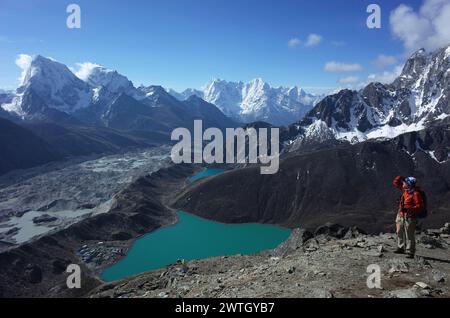 Wandern in Nepal Himalaya, männlicher Tourist auf Gokyo Ri mit Blick auf den Gokyo See, Gokyo Dorf, Ngozumba Gletscher und Berge. Gletschersee in großer Höhe Stockfoto