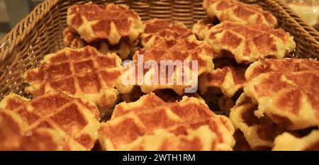 Jede Menge köstlicher, frisch gebackener belgischer Waffeln in einem Korb Stockfoto