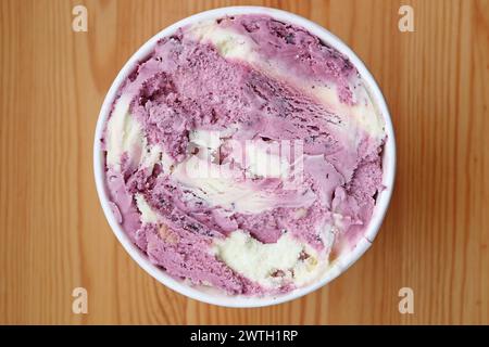 Blick von oben auf Blaubeeren-Joghurt-Eis in einer großen Tasse auf Holztisch Stockfoto