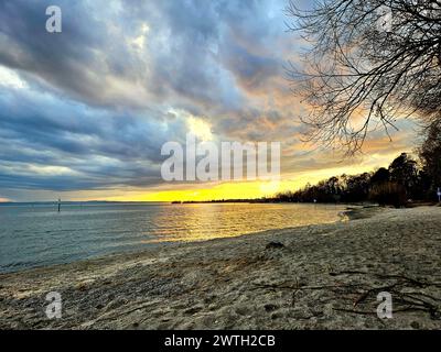 Der Sonnenuntergang über dem Friedrichshafener See mit Strand, Sand und Abendhimmel Stockfoto