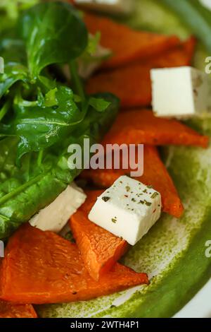 Salat aus Kürbis, Spinat, Fetakäse und Kirschtomaten. Garniert mit Sauce. Keto-Diät. Kopierbereich Stockfoto