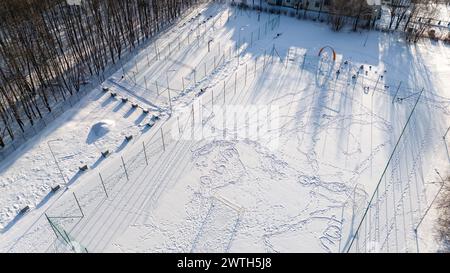 Drohnenfotografie von Fußball-, Basketball- und Volleyballfeldern, die während des sonnigen Wintertages von Schnee bedeckt sind Stockfoto