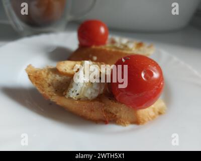 Camembert-Käse gebacken mit Tomaten und Baguette, Kräutern und Knoblauch. Eine ausgezeichnete Vorspeise für Wein. Stockfoto