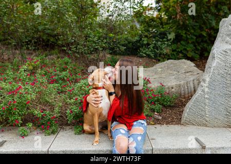 Ein freudiger Moment zwischen einer Frau und ihrem Hund im Garten Stockfoto