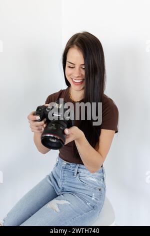 Glückliche Frau, die die Aufnahmen mit der Canon Kamera überprüft Stockfoto
