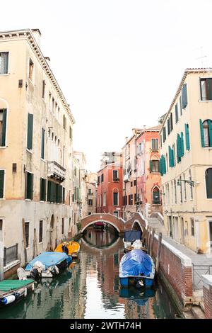 Kanal gesäumt von Booten und venezianischen Häusern Stockfoto