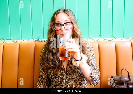 Eine hübsche 32-jährige Frau, die Eistee trinkt. Stockfoto