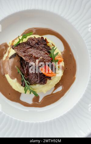 Rinderfilet gedünstet mit Kräutern in Soße und garniert auf einem Pl Stockfoto