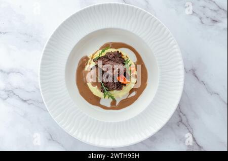 Rinderfilet gedünstet mit Kräutern in Soße und garniert auf einem Pl Stockfoto