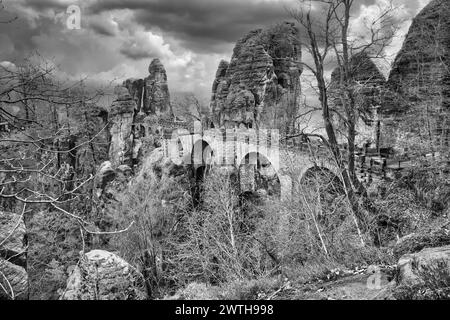 Die Basteibrücke in der Sächsischen Schweiz in Schwarz-weiß. Zerklüftete Felsen, Aussichtsplattform mit Blick auf die Elbe. Touristenattraktion. Dramatischer Himmel. Nati Stockfoto