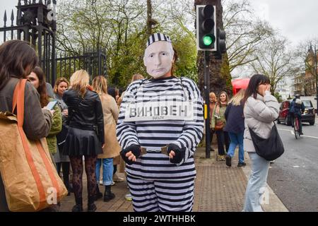 London, Großbritannien. März 2024. Ein als Putin gekleideter Demonstrant in Gefängniskleidung und Handschellen läuft vor der russischen Botschaft vorbei an russischen Bürgern, die sich um ihre Stimme schlangen, während Wahlen in Russland stattfinden. Quelle: Vuk Valcic/Alamy Live News Stockfoto