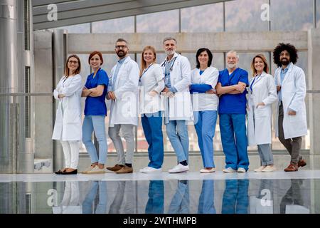 Porträt des Ärzteteams, in voller Länge mit Reflexion. Gesundheitsteam mit Ärzten, Krankenschwestern, Fachleuten in medizinischen Uniformen im Krankenhaus. Stockfoto