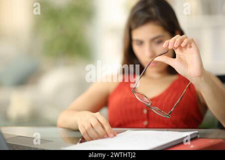 Gelangweilter Schüler, der mit Brillen spielt, verschwendet zu Hause Zeit Stockfoto