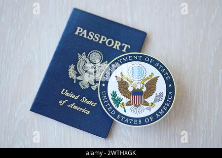 KIEW, UKRAINE - 9. MÄRZ 2024 Siegel des US-Außenministeriums und US-Pass auf Holztisch in Nahaufnahme Stockfoto