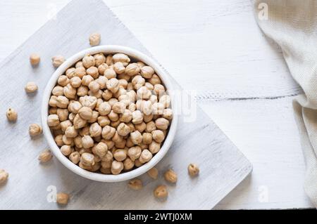 Ungekochte getrocknete Kichererbsen in einer Schüssel oder einem Löffel auf dem Tisch. Haufen von Leguminosen Kichererbsenhintergrund Stockfoto