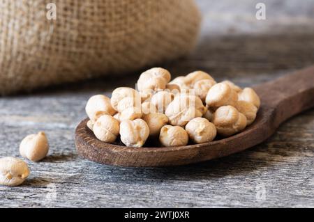 Ungekochte getrocknete Kichererbsen in einer Schüssel oder einem Löffel auf dem Tisch. Haufen von Leguminosen Kichererbsenhintergrund Stockfoto