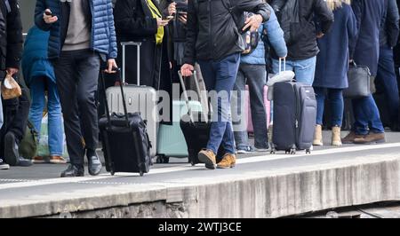 Hannover, Deutschland. März 2024. Reisende stehen mit Taschen und Koffern auf einer Schiene am Hauptbahnhof Hannover. Beide Seiten des Lohnstreits bei der Deutschen Bahn haben die Verhandlungen wieder aufgenommen. Das Unternehmen und die zugführergewerkschaft GDL sind zuversichtlich, dass diese Woche eine Einigung erzielt wird, so eine Erklärung der Deutschen Bahn. Quelle: Julian Stratenschulte/dpa/Alamy Live News Stockfoto