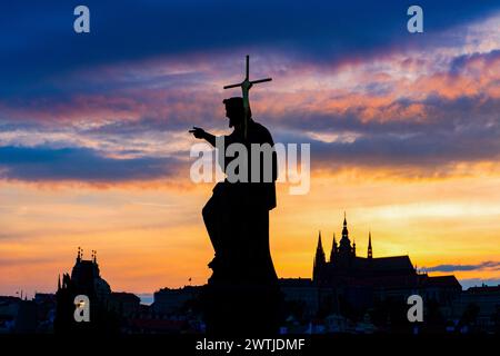 St. Johannes-Täufer-Statue auf der Karlsbrücke, Prag, Tschechische Republik, mit St.-Veitsdom und dem Brückenturm des kleinen Viertels Stockfoto