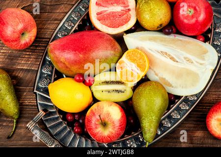 Äpfel, Birnen, Mangos und Zitrusfrüchte auf einem stilvollen Tablett. Stockfoto