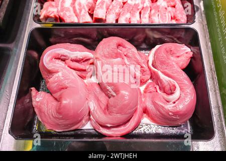 Verschiedene Stücke von Schweinefleisch Steaks, verschiedene Körperteile, die Fleisch zum Verkauf in Behältern an einer Ladentische schneiden Stockfoto