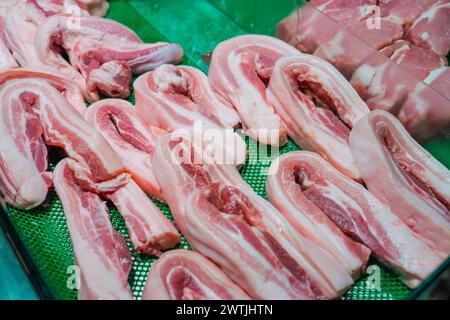 Speckschicht aus Schmalz verschiedene Teile von Schweinefleisch Steaks, verschiedene Körperteile, die Fleisch zum Verkauf in Behältern an einer Ladentische zerlegen Stockfoto