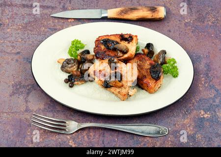 Gebratene Schweinemedaillons Steaks aus Filet mit Pilzen auf einem Teller. Stockfoto