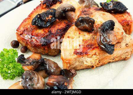 Gebratene saftige Schweinemedaillons Steaks aus Filet mit Pilzen auf einem Teller. Stockfoto