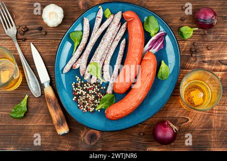 Trocken geräucherte Kabanos, Cabanossi. Traditionelle polnische Fleischwürste. Schweinefleisch- oder Rindfleischwurst auf einem rustikalen Tisch. Stockfoto