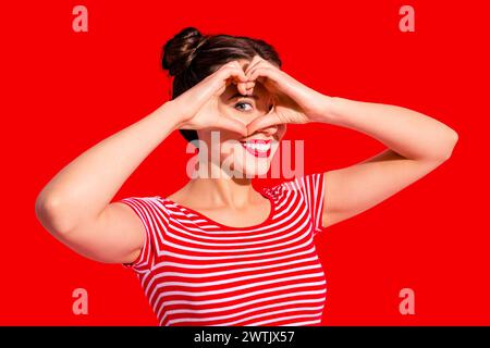 Nahaufnahme Foto schön sie ihre Dame hübsch zwei Buns Pomade Lippen halten Hände Arme Herzform Figur in der Nähe Augenhaut Gesicht Herz Gesundheit Kleidung Freizeit Stockfoto