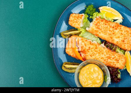 Pollock-Filet in Semmelbröseln geröstet, serviert mit Sauce und Kiwi. Leerzeichen für Text. Stockfoto