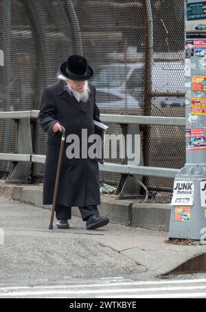 Ein älterer orthodoxer Jude geht auf der Lee Ave nach Hause, auf der Überführung zum Brooklyn, Queens Expressway. Seine Peyus weht im Wind. In Brooklyn, New. Stockfoto