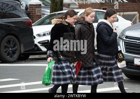 Orthodoxe jüdische Klassenkameraden, die dieselben Schottenröcke tragen, überqueren eine Straße in Brooklyn, New York. Stockfoto