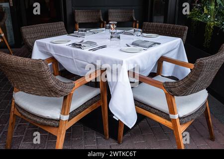 Trinkgläser und Tischdecken auf dem Tisch. Innenseite einer Sommerterrasse des Restaurants. Tisch und Stühle in leerem Café. Im Freien leerer Kaffee und Ruhe Stockfoto