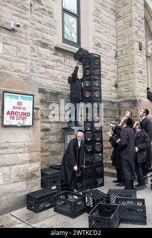 Ultraorthodoxe jüdische Jeschiva-Schüler in einer städtischen Schule bauen während ihrer Pause einen Turm aus Milchkisten. In New York City. Stockfoto