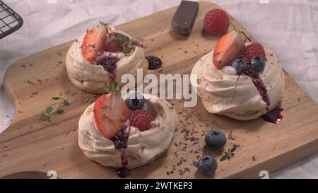 Kleine pavlova-Kuchen mit frischen Erdbeeren und Heidelbeeren. Stockfoto