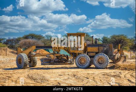 Gelbgrader, der die Erde auf einer Baustelle in einer Diamantmine gräbt Stockfoto