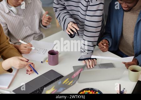 Nahaufnahme eines jungen Geschäftsteams, das über einem Meeting-Tisch arbeitet und mit einem Laptop arbeitet Stockfoto