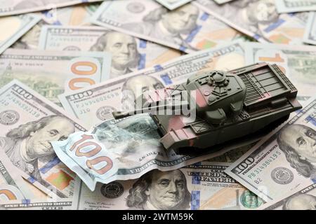 Tank auf zerknitterten 100-Dollar-Banknoten. Hintergrund der Kriegsfinanzierung und des militärischen Unterstützungspreises für die Vereinigten Staaten von Amerika Stockfoto