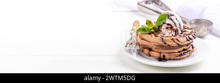 Stapel belgischer Schokoladenwaffeln mit Eis und schokoladenbelag. Frühstückswaffeln mit Eis, Schokoladensoße und Pfefferminze Stockfoto