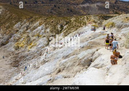 Touristen, die im Stefanos-Krater auf dem Vulkan der Insel Nisyros in Griechenland spazieren. Stockfoto
