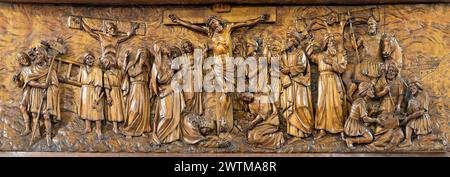 MAILAND, ITALIEN - 5. MÄRZ 2024: Das geschnitzte Relief der Kreuzigung in der Kirche Chiesa di San Camillo von Annibale Pagnoni (1900). Stockfoto