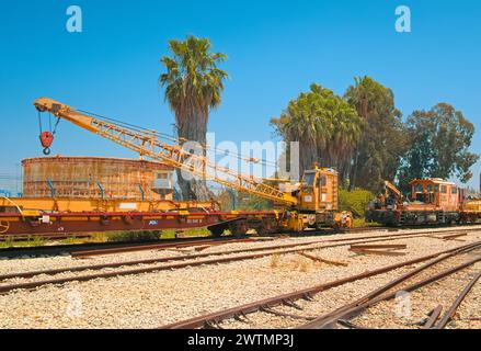 Haifa, Israel - 10. Mai 2023: Blick auf einen Eisenbahnkran und Öllagertank im offenen Bereich des Eisenbahnmuseums ​​the Israel. Stockfoto