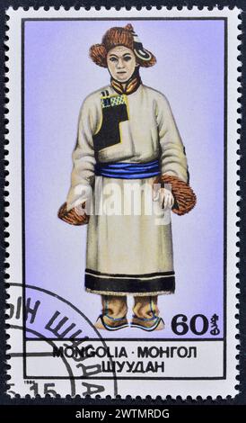 Von der Mongolei gedruckte Briefmarke, die Nationalkostüm zeigt, um 1986. Stockfoto