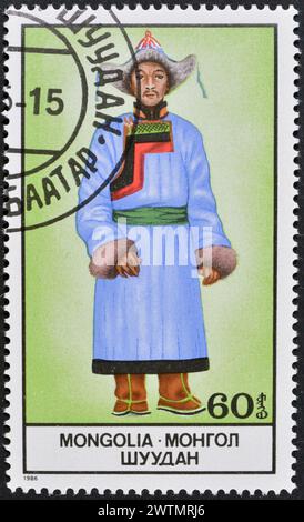 Von der Mongolei gedruckte Briefmarke, die Nationalkostüm zeigt, um 1986. Stockfoto