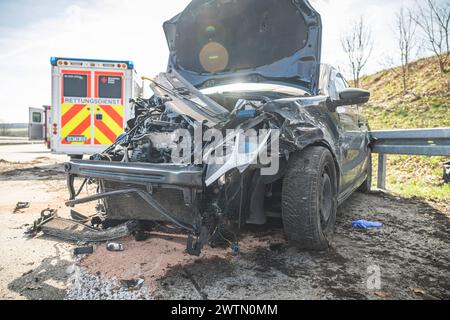 Verkehrsunfalll ein völlig zerstörtes Auto nach einem Verkehrsunfall mit Rettungswagen im Hintergrund Tautendorf Deutschland *** Verkehrsunfall Ein vollständig zerstörtes Auto nach einem Verkehrsunfall mit einem Krankenwagen im Hintergrund Tautendorf Deutschland Stockfoto