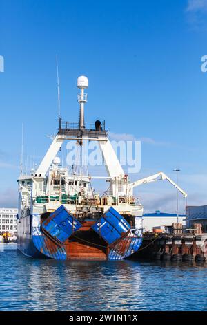 Reykjavik, Island - 4. April 2017: Fischtrawler lädt im Hafen, vertikales Foto eines isländischen Hecktrawlers Stockfoto